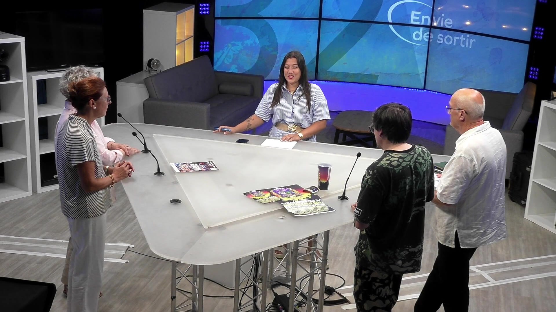 Plateau d'Envie de sortir avec trois invités et des flyers posés sur la table de présentation