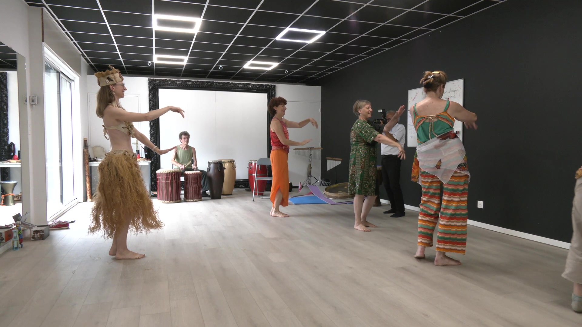 Amandine Robin-Tissandier et Pascal Michaud devant un tableau blanc avec inscriptions sur la danse, djembés visibles