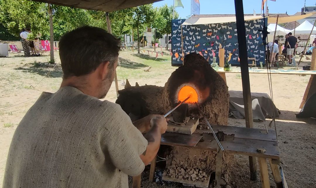 Souffleur de verre introduisant une canne dans un four incandescent lors du Vitrail au Grand Air à Troyes.