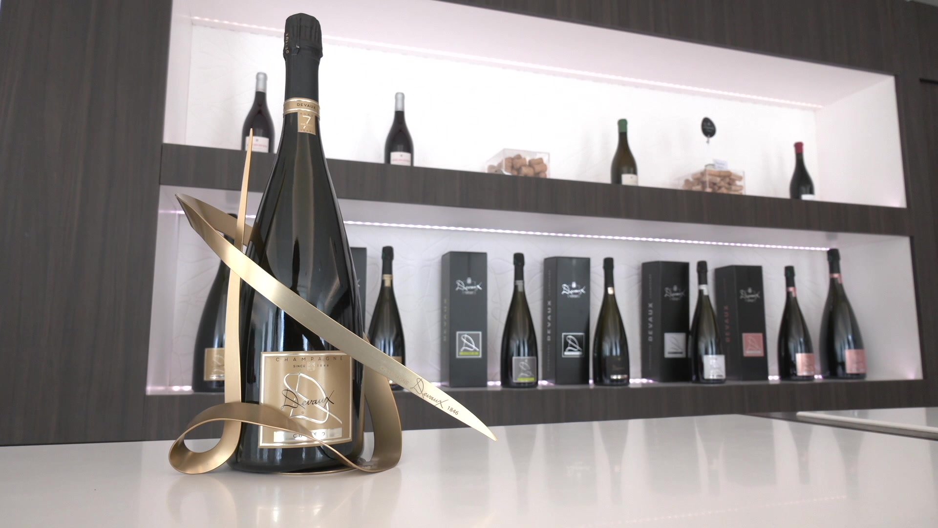 Trois bouteilles de Champagne Devaux alignées : Cuvée D, D Rosé et Ultra D, étiquettes visibles sur fond blanc