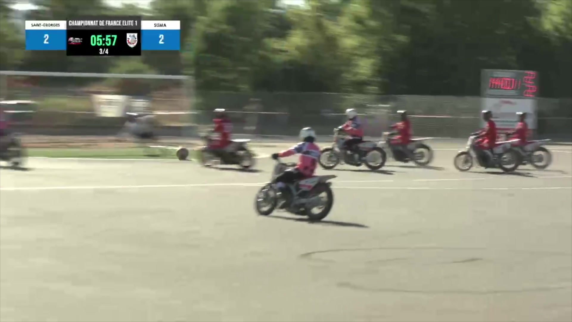 Joueurs de motoball en maillots rouges sur motos sur terrain, score 2-2 au 3e quart-temps affiché