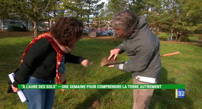 Chercheur et agricultrice examinent un échantillon de terre en plein air