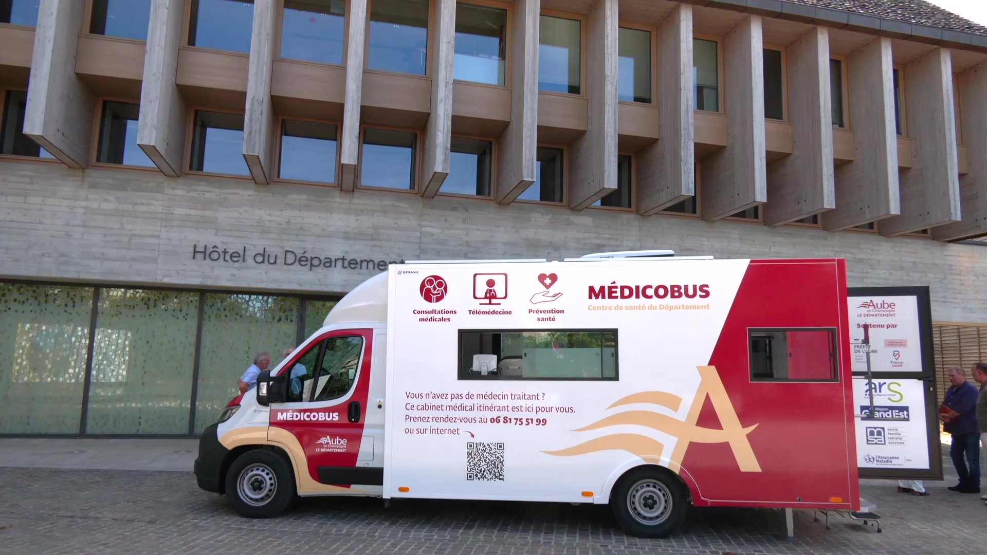 Consultation médicale dans un cabinet : patiente avec chemise jaune face à un médecin devant un ordinateur portable