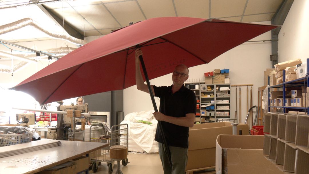 Couturière assemblant à la machine à coudre une toile de parasol à motifs floraux dans l'atelier Dess à Piney