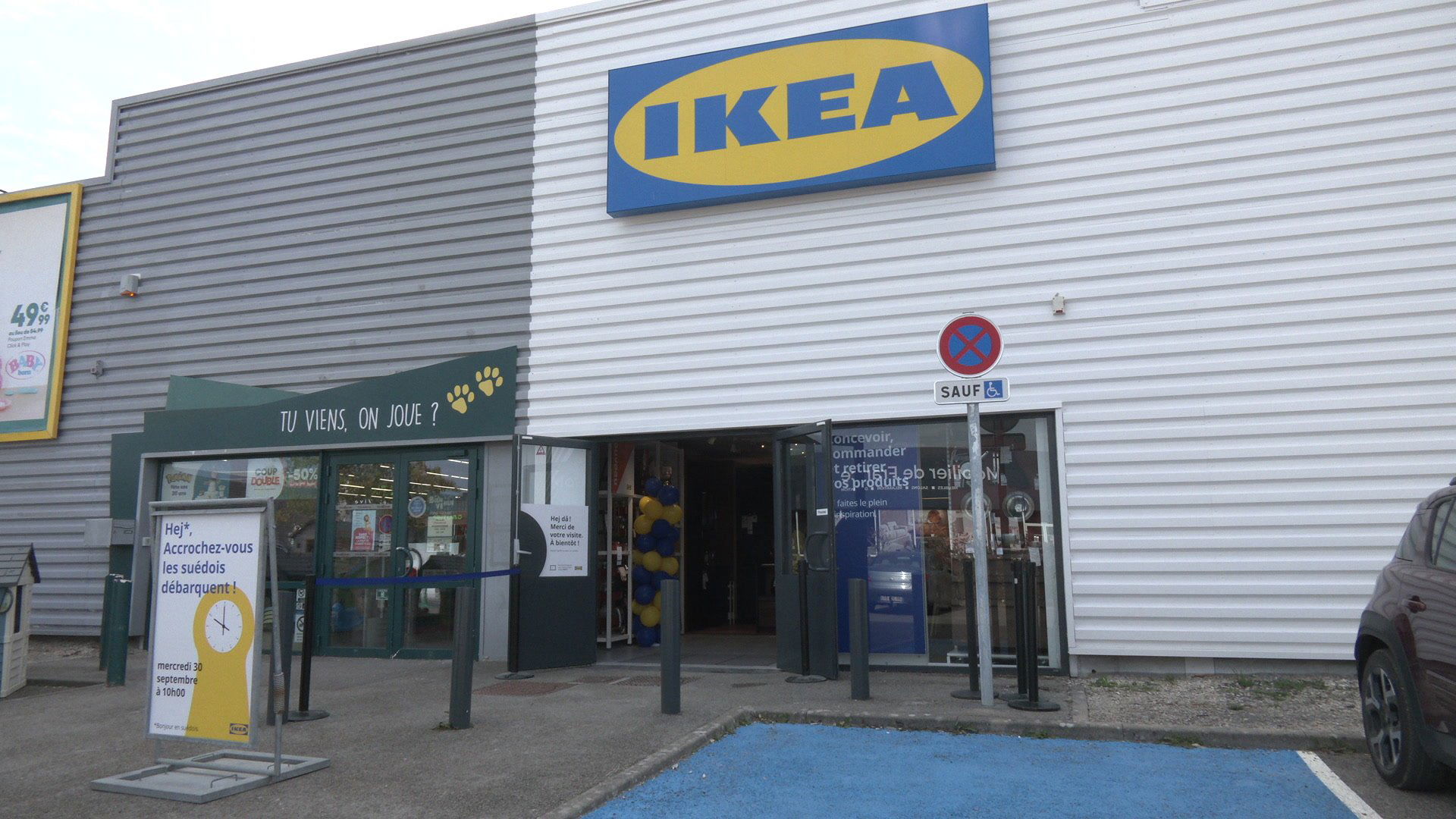 Directrice IKEA en t-shirt jaune devant une cuisine noire exposée en showroom
