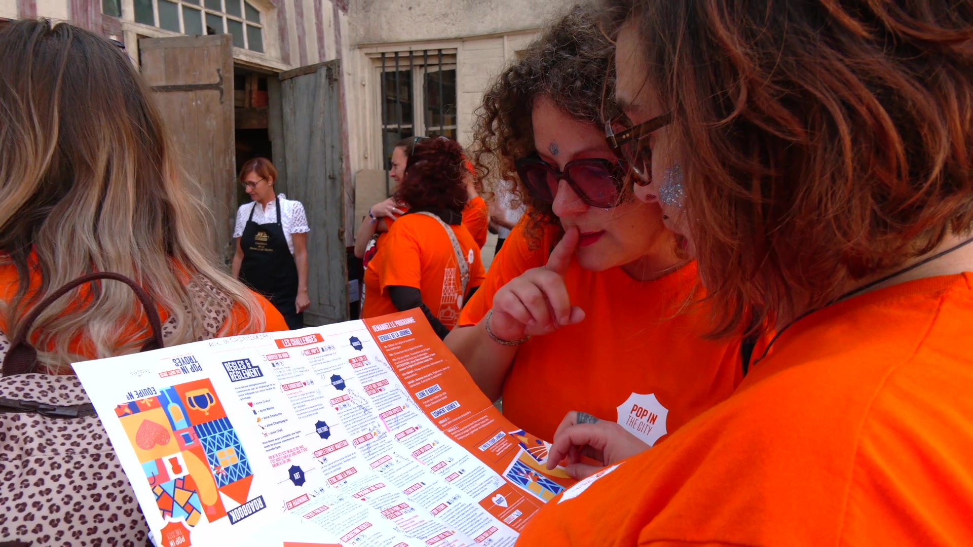 Participante en maillot orange avec collier hawaï multicolore devant la préfecture de Troyes