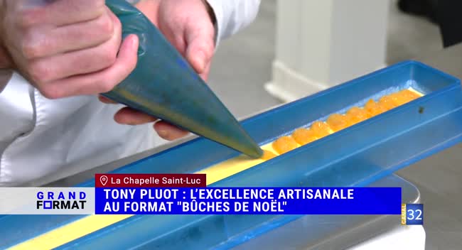 Pâtissier travaillant le pochage sur une bûche de Noël en atelier
