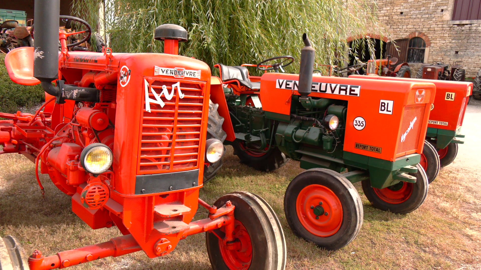 Tracteur Vendeuvre orange avec calandre en grille métallique et aile papillon, garé contre un mur blanc