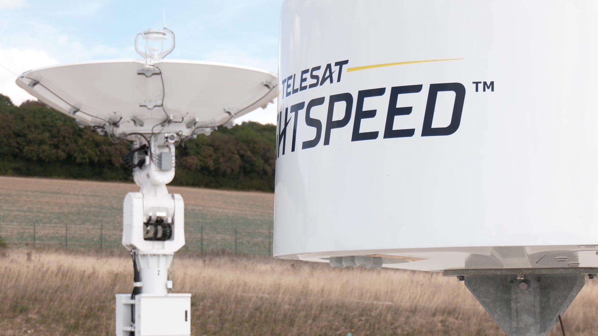 Yanniv Betito s'exprime devant une antenne satellite sur le site de Bercenay-en-Othe, champs et forêt en arrière-plan