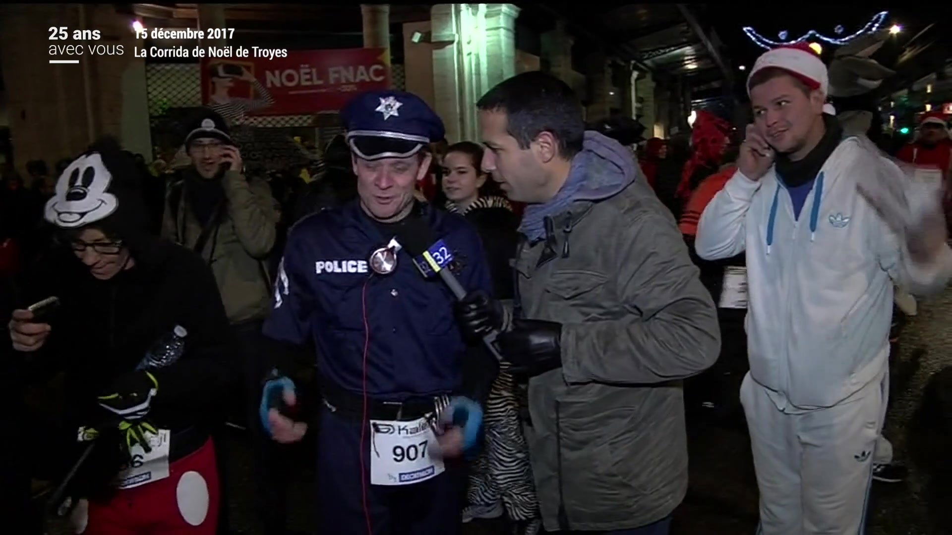 Coureur déguisé en clown avec casque orange interviewé par un journaliste Canal 32 dans les rues de Troyes la nuit