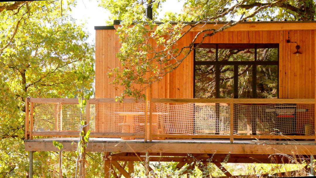Deux cabanes en bois posées dans une prairie ouverte entourée d'arbres, reliées par un chemin sinueux à Ervy-le-Châtel