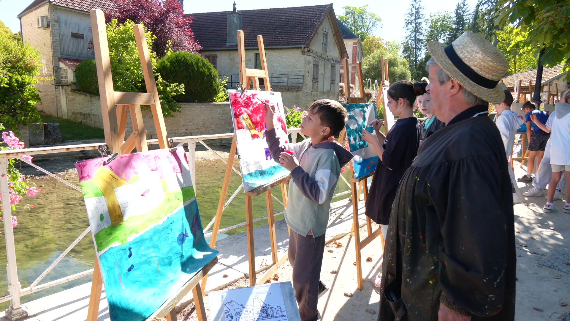 Enfant peignant sur un chevalet en plein air