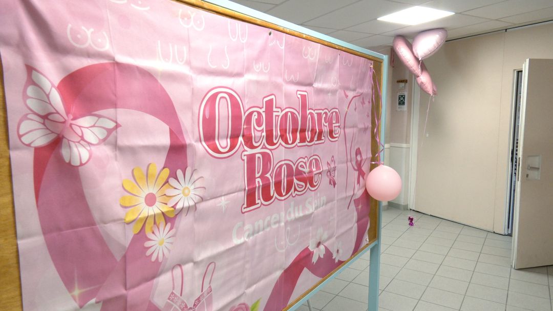 Kakémono de la Ligue contre le cancer affiché dans une salle de classe au plafond blanc, avec slogan Ensemble agissons c