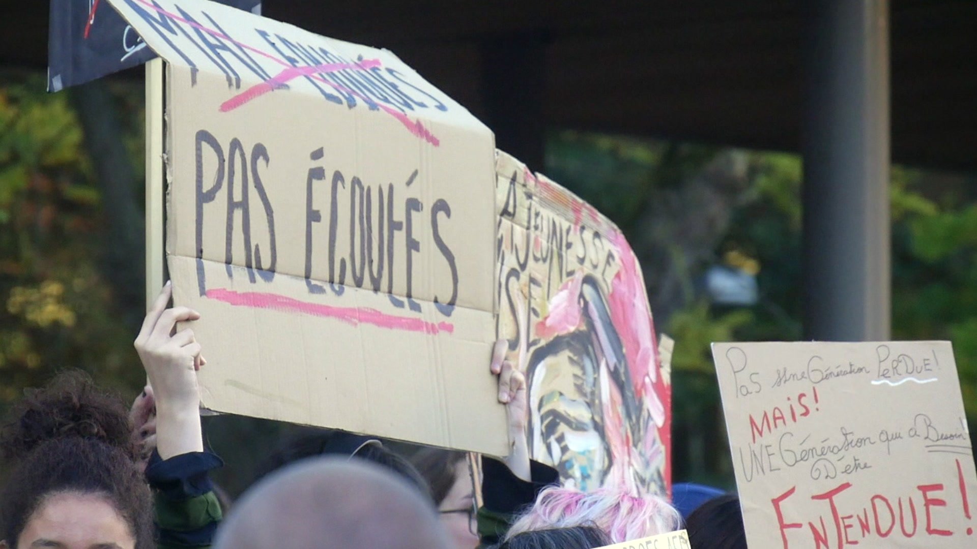 Lycéens manifestant avec pancartes dont 'Tout bloquer devient vital' devant un lycée