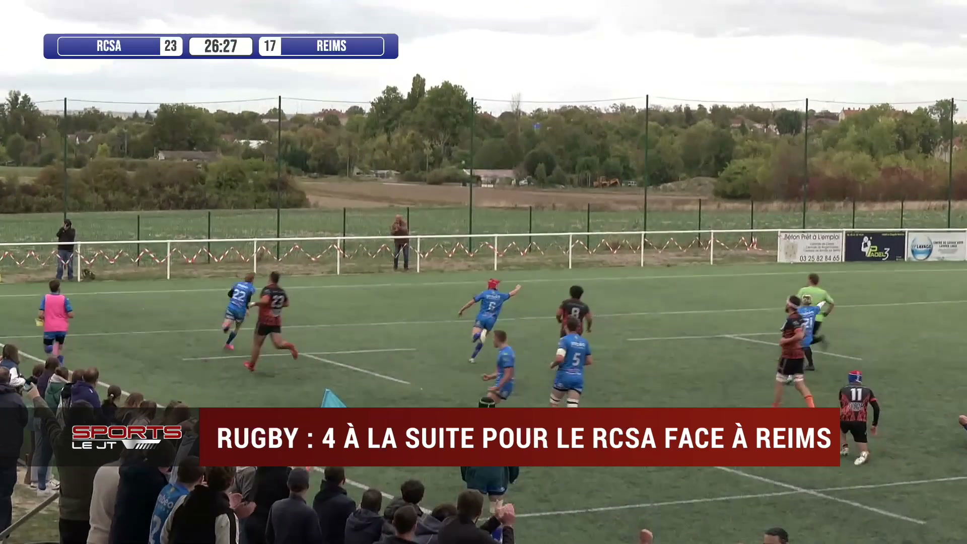 Match de rugby RCSA contre Reims, score 23-17 affiché, joueurs en maillots bleus et noirs sur terrain herbeux