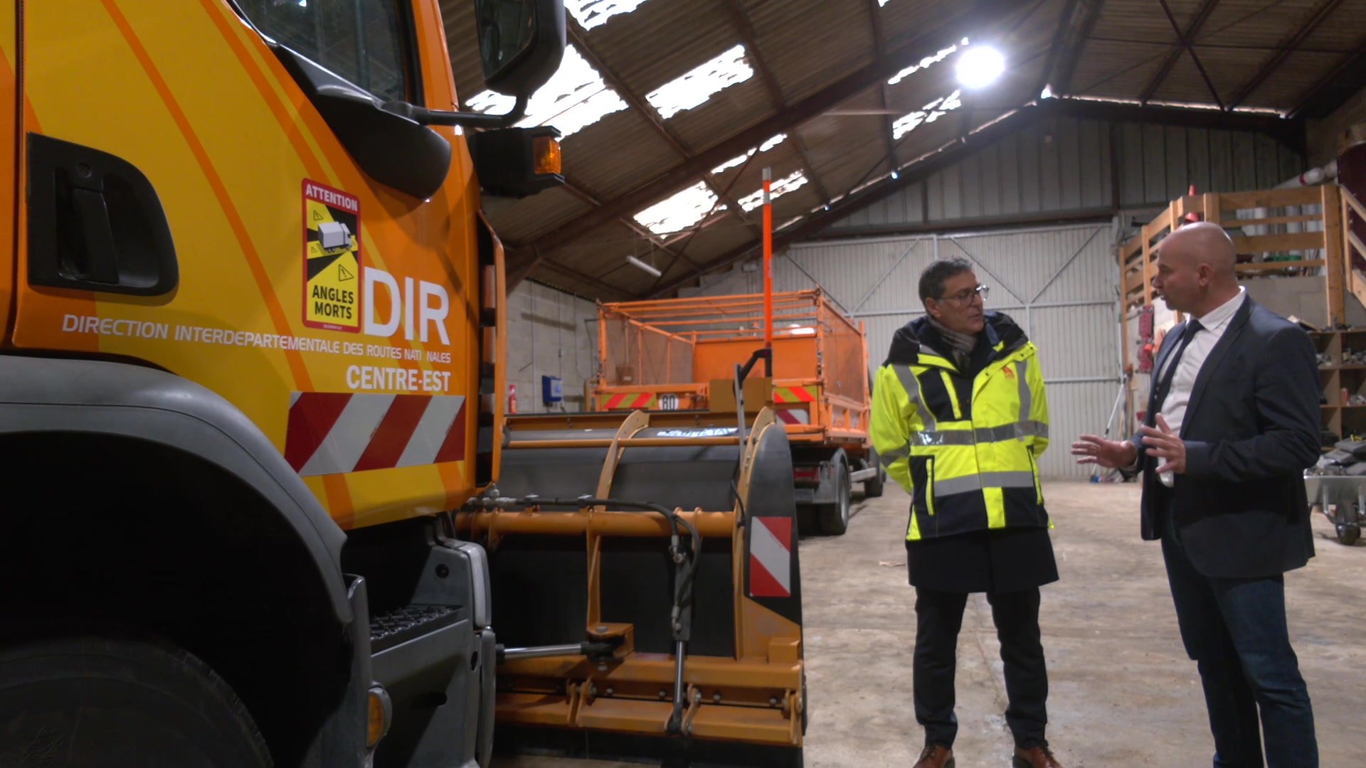 Panneau orange DIR Centre-Est avec panneau stop et route bidirectionnelle en arrière-plan