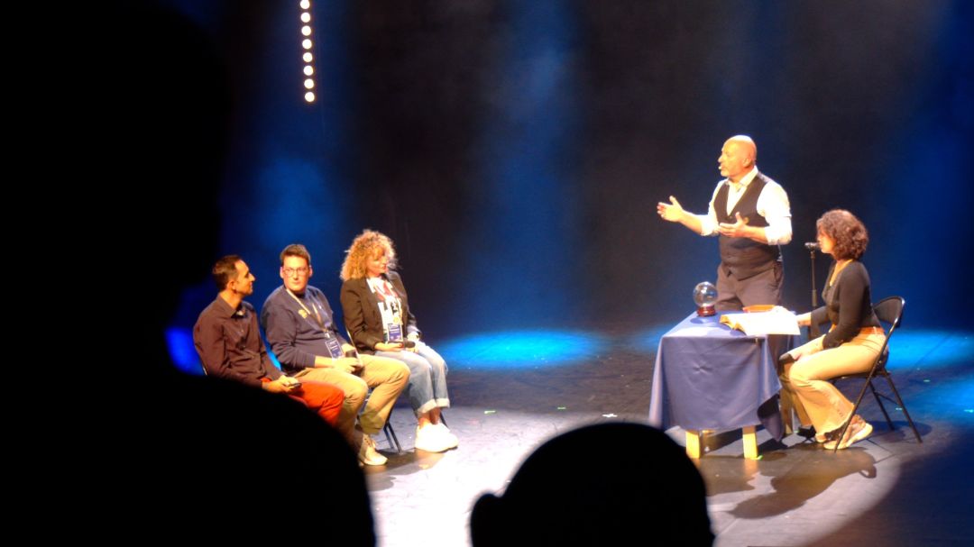 Salle de spectacle plongée dans le noir, championnat français de magie