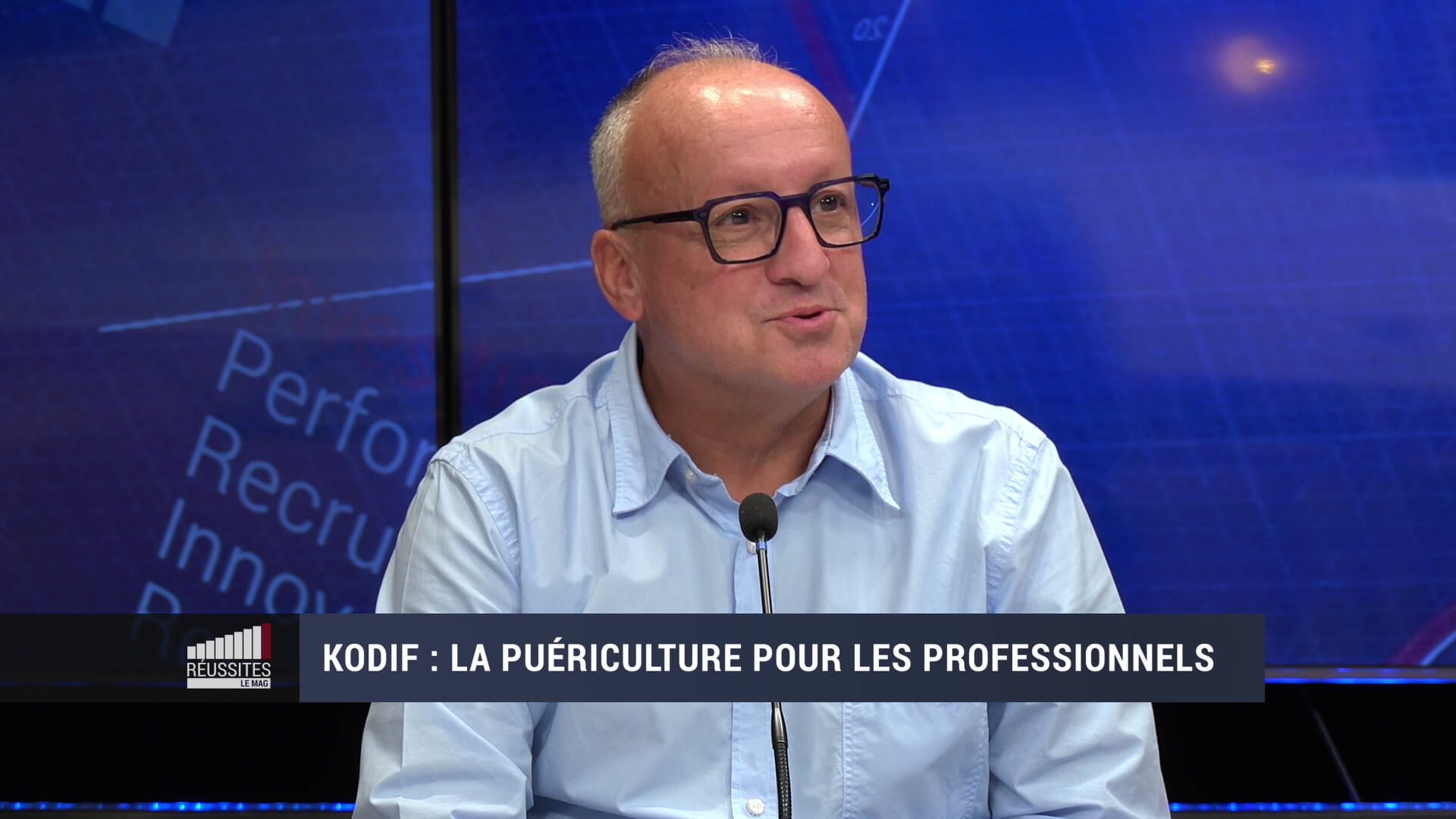 Table d'éveil pour enfants avec perles colorées et fils métalliques devant un panneau Kodif