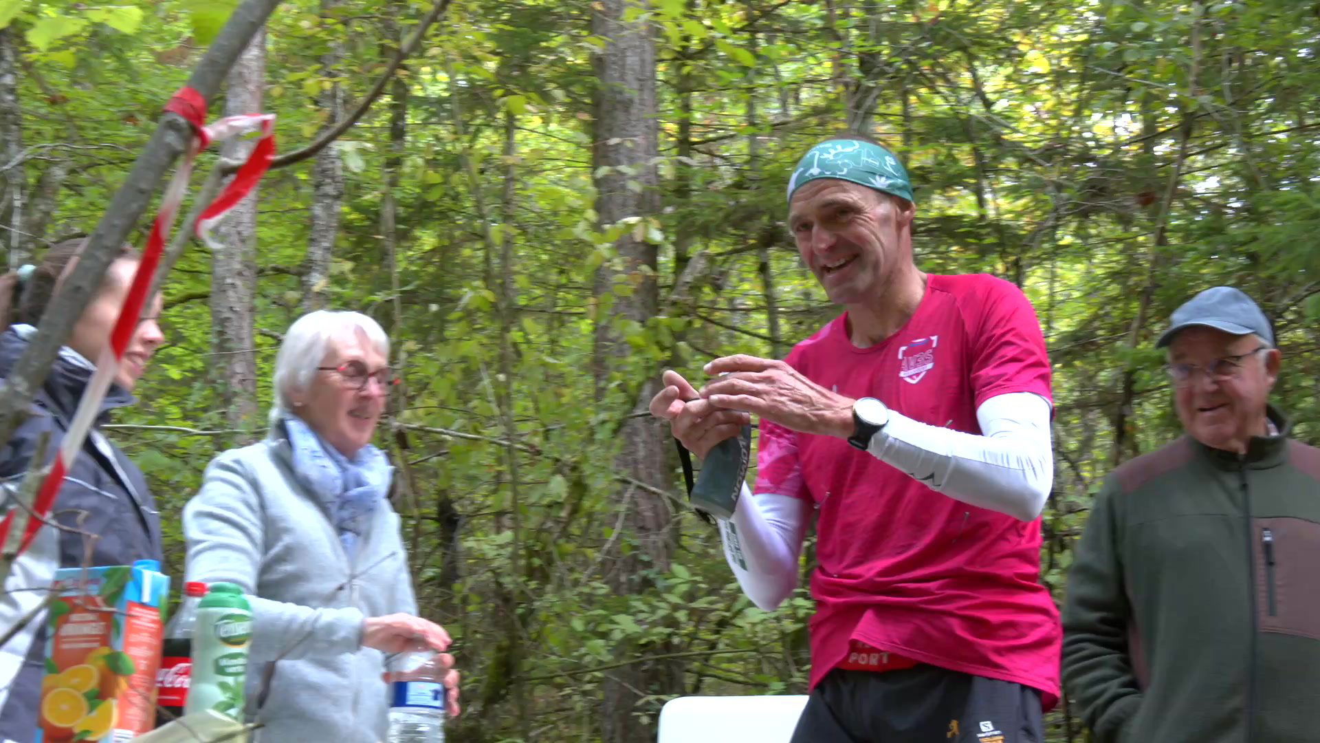 coureur en short jaune et t-shirt noir progressant sur un sentier herbeux bordé d'arbres lors du trail des cadoles